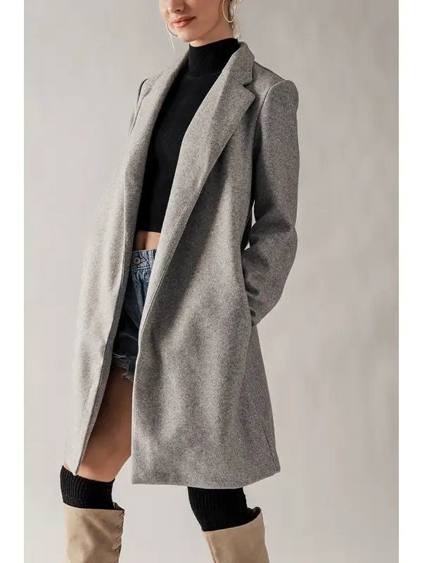 Grey overcoat with front lapels and side pockets, midi length.