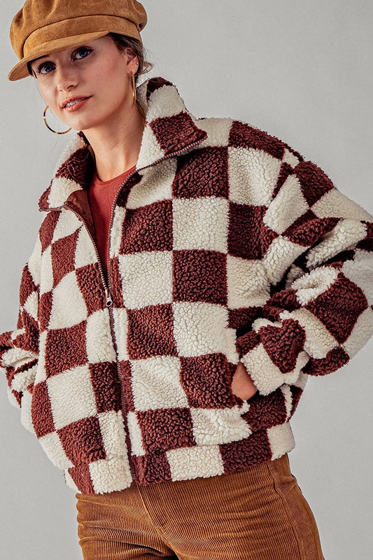 White and rust colored checkered sherpa zip bomber style jacket with collar and front pockets. zipper front closure.